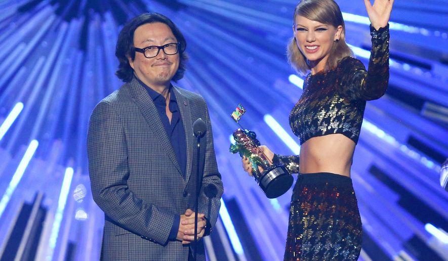 FILE - In this Aug. 30, 2015 file photo, director Joseph Kahn, left, and Taylor Swift appear on stage as Swift accepts the award for female video of the year for “Blank Space” at the MTV Video Music Awards in Los Angeles. Kahn, the director of Swift’s new music video is defending the singer after some claimed she whitewashed her video based in Africa. He said in a statement Wednesday, Sept. 2, that the video for “Wildest Dreams” includes black people and was produced by a black woman and edited by a black man. (Photo by Matt Sayles/Invision/AP, File)