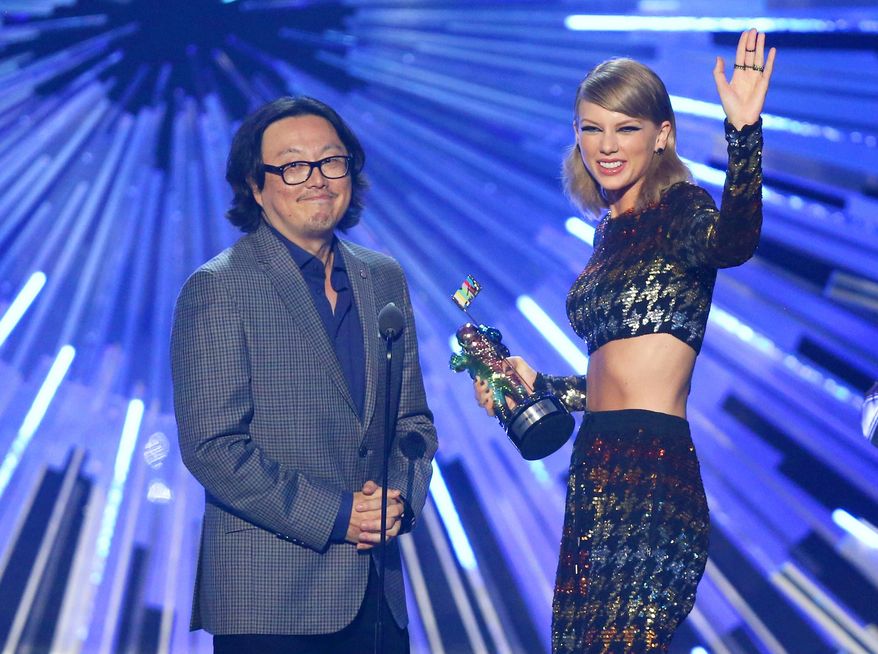 FILE - In this Aug. 30, 2015 file photo, director Joseph Kahn, left, and Taylor Swift appear on stage as Swift accepts the award for female video of the year for “Blank Space” at the MTV Video Music Awards in Los Angeles. Kahn, the director of Swift’s new music video is defending the singer after some claimed she whitewashed her video based in Africa. He said in a statement Wednesday, Sept. 2, that the video for “Wildest Dreams” includes black people and was produced by a black woman and edited by a black man. (Photo by Matt Sayles/Invision/AP, File)