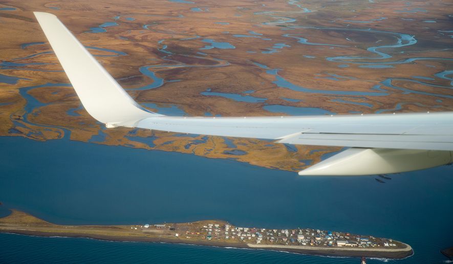 Air Force One, carrying President Barack Obama, flies over the island village of Kivalina, an Alaska Native community of 400 people already receding into the ocean as a result of rising sea levels, on its way to Ralph Wien Memorial Airport, Wednesday, Sept. 2, 2015, in Kotzebue, Alaska. Residents of the Native village threatened by erosion were thankful Wednesday for President Barack Obama's attention to their plight, saying they hope his visit to Alaska will help them secure funding to build a critical evacuation road to drier ground. (AP Photo/Andrew Harnik)