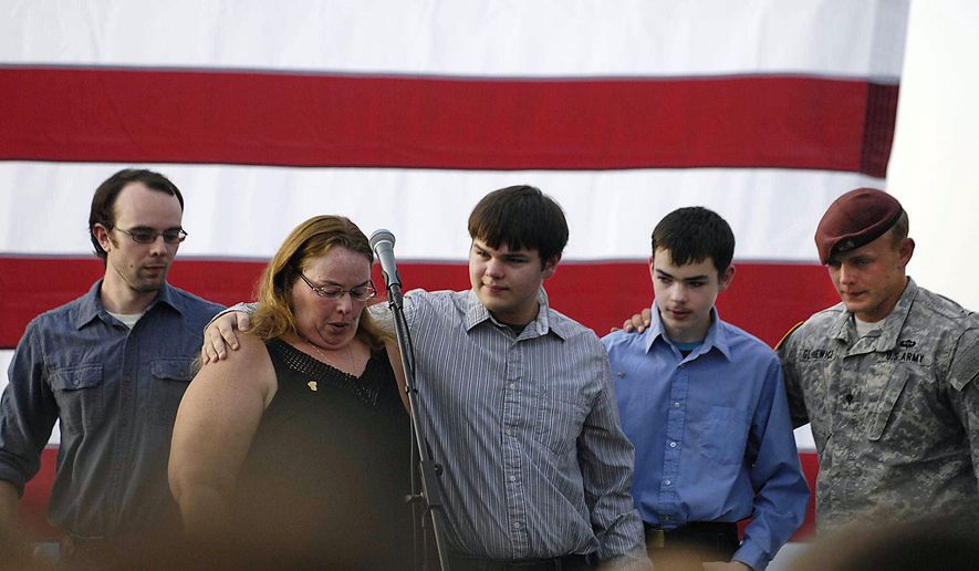 The family of the slain officer react on stage during a vigil at Lakefront Park to honor Lt. Charles Joseph Gliniewicz, Wednesday, Sept. 2, 2015, in Fox Lake, Ill. Gliniewicz was shot and killed Tuesday while pursuing a group of suspicious men. Authorities broadened the hunt Wednesday for the suspects wanted in the fatal shooting. (John Starks/Daily Herald via AP)