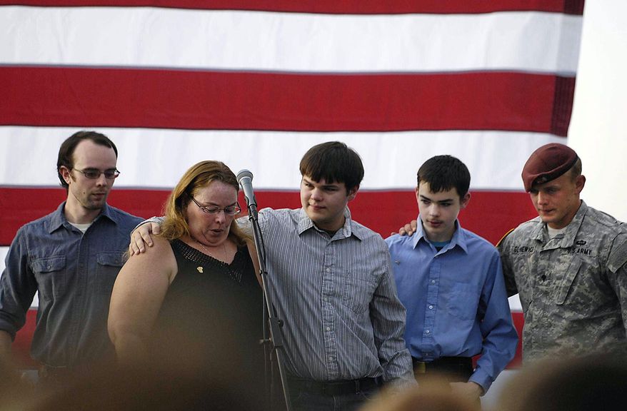 The family of the slain officer react on stage during a vigil at Lakefront Park to honor Lt. Charles Joseph Gliniewicz, Wednesday, Sept. 2, 2015, in Fox Lake, Ill. Gliniewicz was shot and killed Tuesday while pursuing a group of suspicious men. Authorities broadened the hunt Wednesday for the suspects wanted in the fatal shooting. (John Starks/Daily Herald via AP)