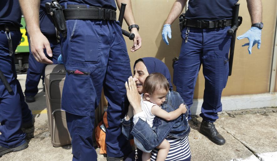 A migrant is detained in Bicske, Hungary, Thursday, Sept. 3, 2015. Over 150,000 migrants have reached Hungary this year, most coming through the southern border with Serbia. Many apply for asylum but quickly try to leave for richer EU countries. (AP Photo/Petr David Josek)