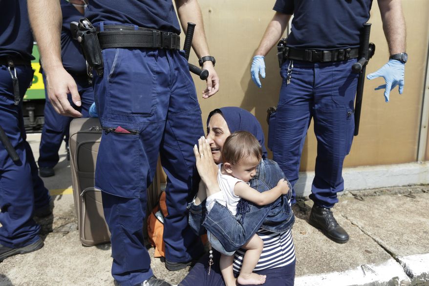 A migrant is detained in Bicske, Hungary, Thursday, Sept. 3, 2015. Over 150,000 migrants have reached Hungary this year, most coming through the southern border with Serbia. Many apply for asylum but quickly try to leave for richer EU countries. (AP Photo/Petr David Josek)
