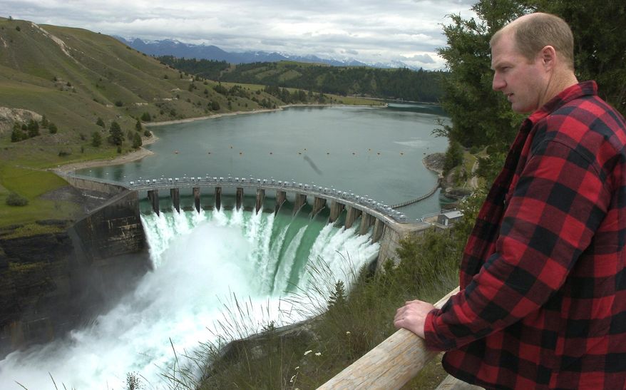 FILE - In this June 8, 2005 file photo Terry McAllister, of Bigfork, Mont., checks out the Kerr Dam, near Polson, Mont. People with business and conservation interests on the Flathead Indian Reservation are asking a judge to temporarily block federal officials from authorizing the transfer of the hydroelectric dam in northwestern Montana to the Confederated Salish and Kootenai Tribes. (Chris Jordan/Daily Inter Lake via AP, File) MANDATORY CREDIT