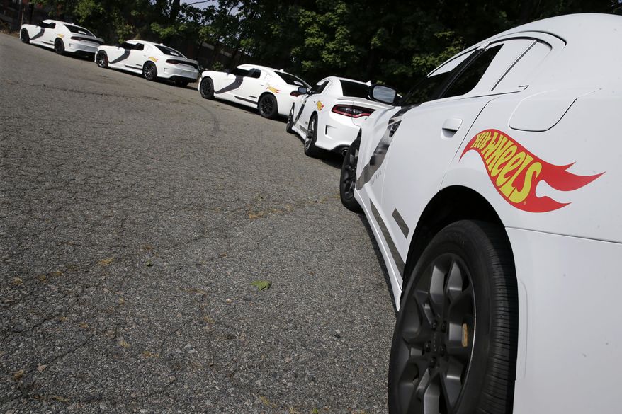 A row of Star Wars decorated Dodge Chargers modeled after a First Order Stormtrooper Car are lined up outside a warehouse Thursday, Sept. 3, 2015, in Paterson, N.J. Inspired by the film Star Wars, Hot Wheels is taking over New York City on "Force Friday" Sept. 4 with a fleet of Stormtrooper vehicles. (AP Photo/Mel Evans)