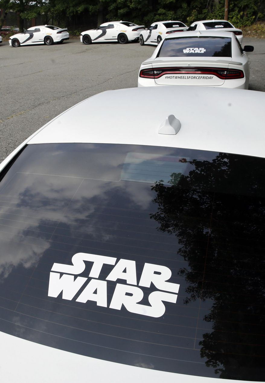 A row of Star Wars decorated Dodge Chargers modeled after a First Order Stormtrooper Car are lined up outside a warehouse Thursday, Sept. 3, 2015, in Paterson, N.J. Inspired by the film Star Wars, Hot Wheels is taking over New York City on "Force Friday" Sept. 4 with a fleet of Stormtrooper vehicles. (AP Photo/Mel Evans)