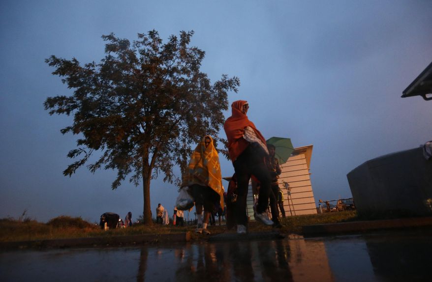 Migrants arrive at the Hungarian-Austrian border in Nickelsdorf, Austria, Saturday, Sept. 5, 2015, where they came from Budapest as Austria in the early-morning hours said it and Germany would let them in. (AP Photo/Petr David Josek)