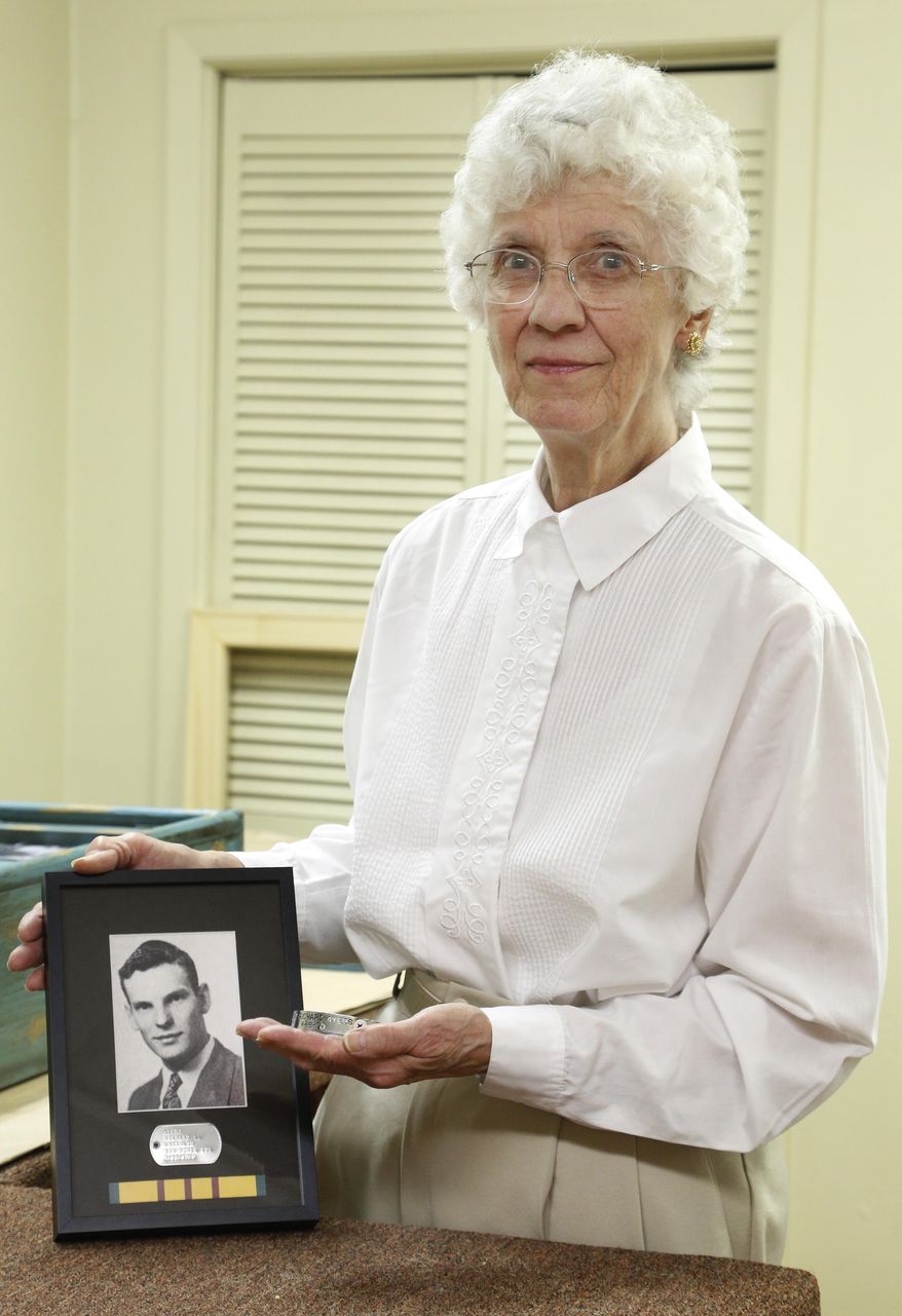 In this photo taken Friday, Aug. 28, 2015, Janice Crowe, aunt of soldier Richard Ayers who went missing in action during theVietnam War, holds a MIA shadow box and bracelet honoring Ayers at Van Doren's Custom Picture Framing in Waterloo, Iowa. On Sept. 18, the Grout Museum District and its Sullivan Brothers Iowa Veterans Museum will hold a special recognition for the Iowa Vietnam MIAs in conjunction. A shadow box for each MIA containing their photo, a replica dog tag and a Vietnam War service ribbon will be presented to family members in attendance or delivered to those unable to attend. (Matthew Putney/The Courier via AP) MANDATORY CREDIT