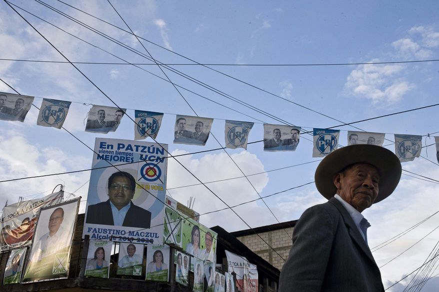 A man walks on a street backdropped by a wall of campaign posters promoting presidential and mayoral candidates, in Patzun, Guatemala, Friday, Sept 4, 2015. A wave of political turmoil that toppled Guatemala's president has overshadowed Sunday's vote to elect a new leader. Tens of thousands who demonstrated for the ouster of President Otto Molina Perez got part of their wishes when the president resigned to face possible corruption charges. But a second demand wasn't met: the postponement of the election that many said offered little alternative to the old guard. (AP Photo/Esteban Felix)