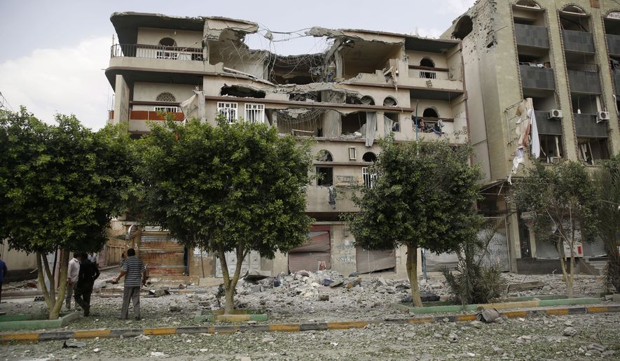 People inspect buildings destroyed by a Saudi-led airstrike in Sanaa, Yemen, Saturday, Sept. 5, 2015. (AP Photo/Hani Mohammed)