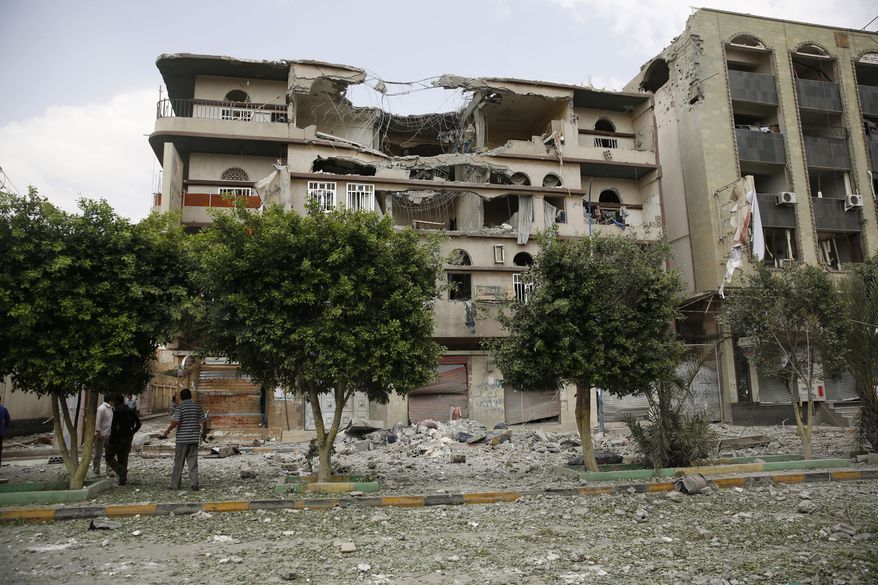 People inspect buildings destroyed by a Saudi-led airstrike in Sanaa, Yemen, Saturday, Sept. 5, 2015. (AP Photo/Hani Mohammed)
