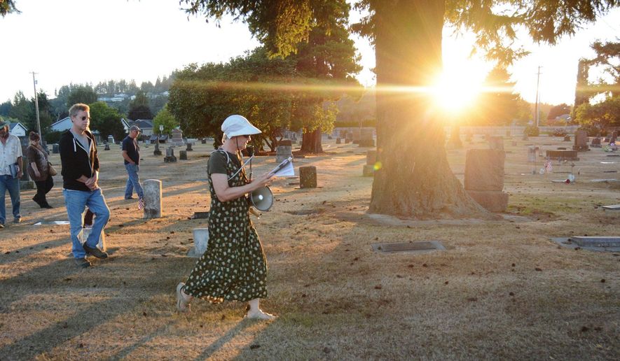 ADVANCE FOR USE MONDAY, SEPT. 7 - In this photo taken Aug. 18, 2015, “The Silent Stones Speak” tour guide Margie Wilson, of the Burlington Historical Society guides the participants through the Green Hills Cemetary in Burlington, Wash., in search of unique headstones that offer symbols and shapes for interpretation. (Brandy Shreve/Skagit Valley Herald via AP) MANDATORY CREDIT