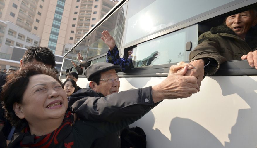 South Korean Nam Gung Bong-ja (left) cries as she holds the hand of her North Korean father Nam Gung Ryuck on a bus after a separated family reunion meeting at Diamond Mountain in North Korea on Feb. 25, 2014. The participants had only three days to meet with relatives most of them hadn't seen since the Korean War ended in an armistice in 1953. (Associated Press)