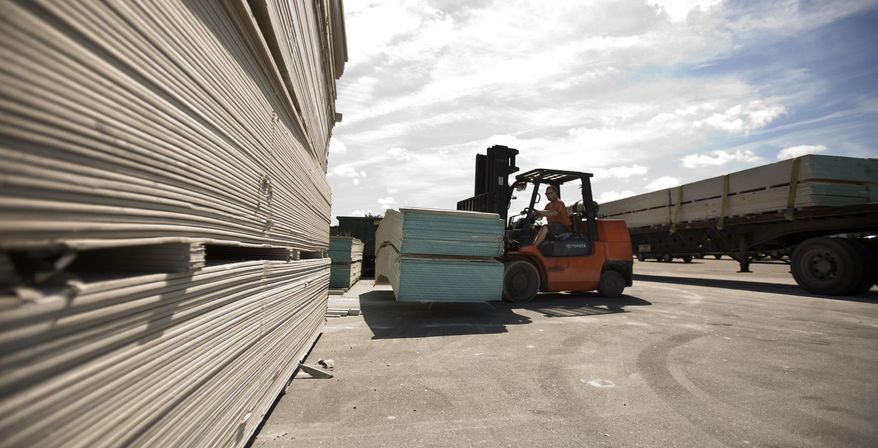 FILE - In this May 22, 2009 file photo, Michael Hilton uses a forklift to move sheets of Chinese-made drywall onto a flat bed truck at Venture Supply, Inc. in Norfolk, Va. in preparation for disposal in a Suffolk, Va. landfill. More than a year after suing the Cabinet agency that oversees China’s biggest state-owned companies, lawyers for people who say their homes were ruined by Chinese drywall are still trying to get the lawsuit served. Arguments are scheduled in December 2015 about whether other defendants are shielded as Chinese government agencies. (Bill Tiernan/The Virginian-Pilot via AP, File)