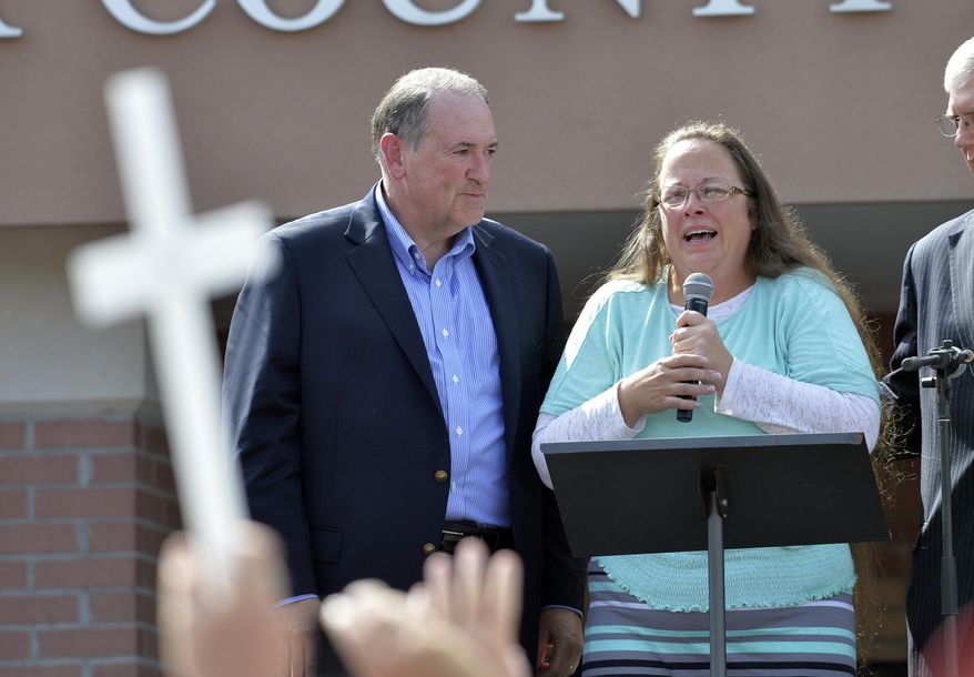 Rowan County Clerk Kim Davis, with Republican presidential candidate Mike Huckabee, left, at her side, speaks after being released from the Carter County Detention Center, Tuesday, Sept. 8, 2015, in Grayson, Ky. Davis, the Kentucky county clerk who was jailed for refusing to issue marriage licenses to gay couples, was released Tuesday after five days behind bars. (AP Photo/Timothy D. Easley)