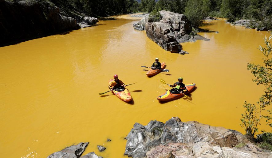 People kayak in the Animas River near Durango, Colo., in water colored with millions of gallons of mine waste into Cement Creek, which flows into the Animas River, on Aug. 6, 2015. (Jerry McBride/The Durango Herald via AP) **FILE**