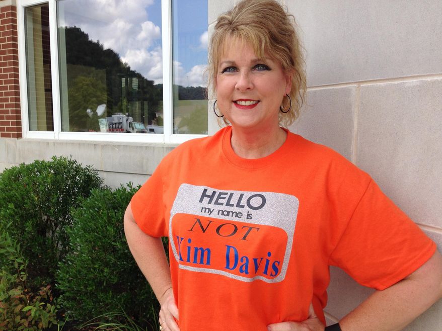 Kim Tabor, a clerk at the judicial center in Morehead, KY., wears a T-shirt to work claiming she is not Kim Davis, the Rowan County clerk, Wednesday Sept. 9, 2015. Tabor, who works across the street from Davis, had the T-shirt made after people confusing her office with Davis' would enter the building and start screaming at her. According to Tabor, the bright orange T-shirt breaks the tension and lightens the mood of those than come into the judicial center. (AP Photo/ Dylan T. Lovan)