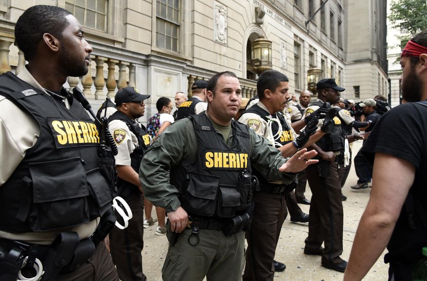 Sheriff's deputies ask people to stay back as protesters rally outside the courthouse at Calvert and Lexington streets in Baktunire during court proceedings Thursday, Sept. 10, 2015, in the Freddie Gray case. Baltimore Circuit Court Judge Barry Williams ruled Thursday that the trials for six police officers charged in the arrest and death of Freddie Gray will be held in Baltimore. The officers' attorneys had said that the days of riots, protests and citywide curfews would make it difficult to choose unbiased jurors in the city. (Barbara Haddock Taylor/Baltimore Sun via AP)