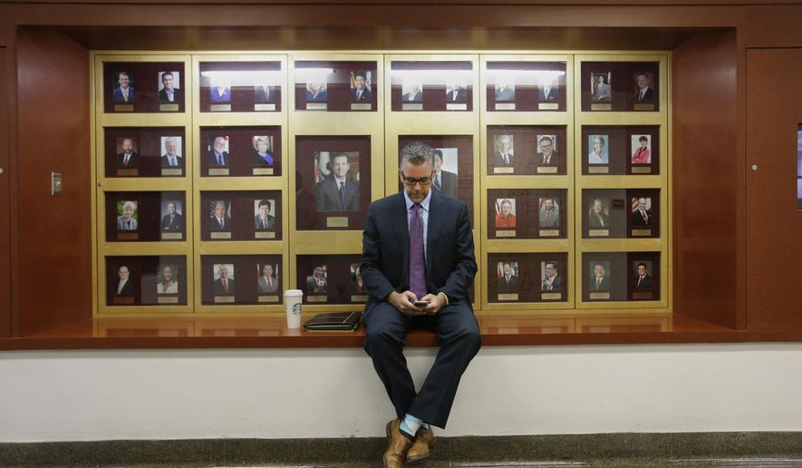 Lobbyist Greg Hayes checks his mobile device outside the Senate Chambers at the Capitol, Thursday, Sept. 10, 2015, in Sacramento, Calif. Lobbyists have been working the hallways to talk to lawmakers about various bills before the end of the legislative session on Friday. (AP Photo/Rich Pedroncelli)