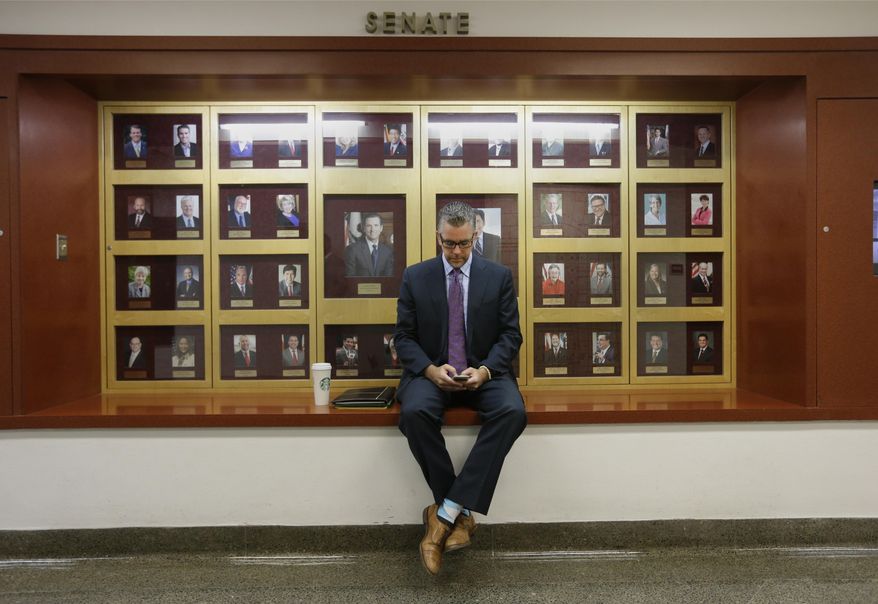 Lobbyist Greg Hayes checks his mobile device outside the Senate Chambers at the Capitol, Thursday, Sept. 10, 2015, in Sacramento, Calif. Lobbyists have been working the hallways to talk to lawmakers about various bills before the end of the legislative session on Friday. (AP Photo/Rich Pedroncelli)
