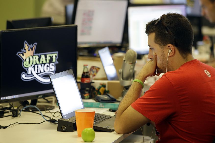 In this Wednesday, Sept. 9, 2015, photo, Devlin D'Zmura, a tending news manager at DraftKings, a daily fantasy sports company, works on his laptop at the company's offices in Boston. The daily fantasy sports industry is eyeing a breakout season as NFL games begin. And its two dominant companies, DraftKings and FanDuel, are touting lucrative opening week prizes to try to draw more customers as more competitors pop up. (AP Photo/Stephan Savoia) ** FILE **