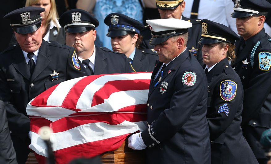 The casket of slain Fox Lake police Lt. Charles Joseph Gliniewicz is loaded into the hearse at Antioch Community High School, in Antioch, Ill., in this Sept. 7, 2015, file photo. (Stacey Wescott/Chicago Tribune via AP, File)