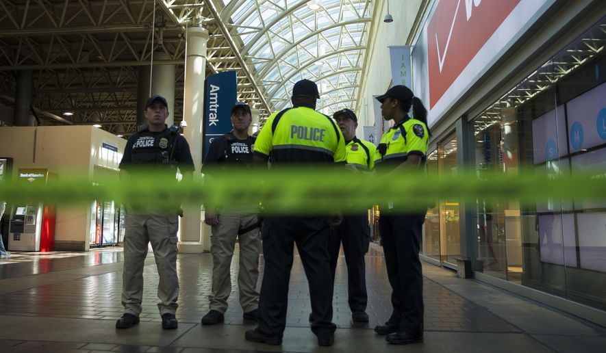 Police and emergency responders stand outside a McDonald's located inside Union Station in Washington on Friday after a security guard shot a suspect who attacked a worker with a knife at the restaurant. (Associated Press)
