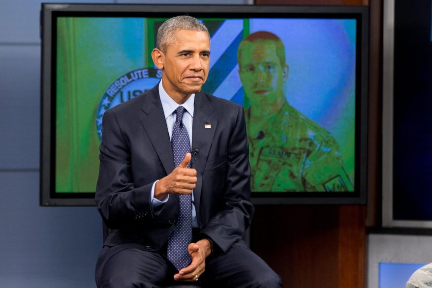 President Barack Obama gives a thumbs up as he takes a question from a service member in Afghanistan, on screen at right, during a town hall with service members at Fort Meade, Md., Friday, Sept. 11, 2015, on the 14th anniversary of the 9/11 attacks. (AP Photo/Andrew Harnik)