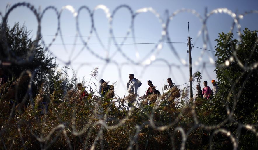 Migrants arrive at the border line between Serbia and Hungary near Roszke, southern Hungary, Sunday, Sept. 13, 2015. Hundreds of thousands of Syrian refugees and others are still making their way slowly across Europe, seeking shelter where they can, taking a bus or a train where one is available, walking where it isn&#x27;t. The latest string of walkers made their way Friday from the Hungarian border across Austria toward the capital, Vienna. (AP Photo/Matthias Schrader)
