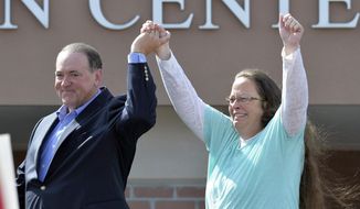 In this Tuesday, Sept. 8, 2015, file photo, Rowan County Clerk Kim Davis, with Republican presidential candidate Mike Huckabee at her side, greets the crowd after being released from the Carter County Detention Center, in Grayson, Ky. (AP Photo/Timothy D. Easley, File)