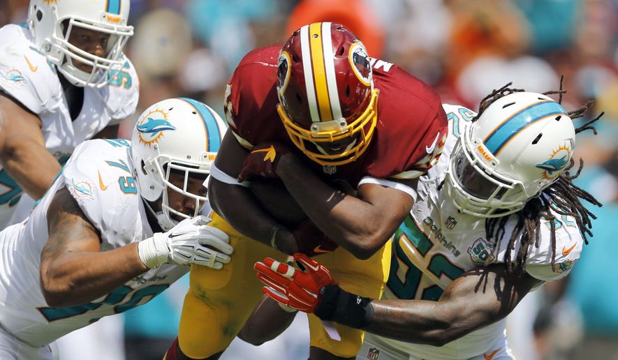 Miami Dolphins defensive end Derrick Shelby (79) and middle linebacker Kelvin Sheppard (52) tackle Washington Redskins running back Alfred Morris (46) during the first half of an NFL football game Sunday, Sept. 13, 2015, in Landover, Md. (AP Photo/Patrick Semansky)