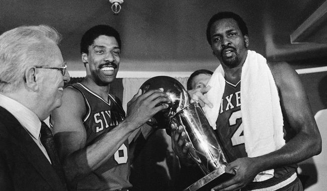FILE - In this Tuesday, May 31, 1983 file photo, Philadelphia 76ers Julius Erving, left, and Moses Malone, right, hold the NBA Championship trophy after defeating the Los Angeles Lakers in  Los Angeles. Malone, a three-time NBA MVP and one of basketball’s most ferocious rebounders, died Sunday, Sept. 13, 2015, according to a The Philadelphia 76ers statement. He was 60. (AP Photo/File)
