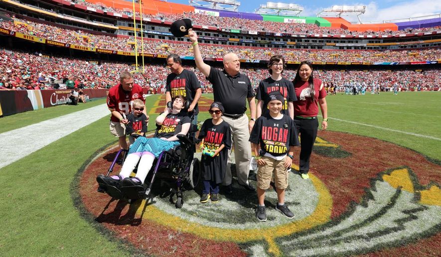 This handout photo provided by the Office of the Governor, taken Sept. 13, 2015, shows Maryland Gov. Larry Hogan, center,  attending the Washington Redskins home opener against the Miami Dolphins, in Landover, Md., along with four children from the Cool Kids Campaign, who are also battling cancer. (Office of the Governor via AP)