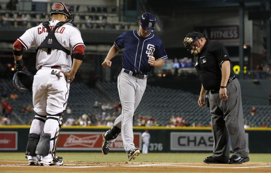 San Diego Padres' Wil Myers, middle, crosses home plate after hitting a home run as Arizona Diamondbacks' Welington Castillo, left, and umpire Bruce Dreckman, right, watch during the first inning of a baseball game, Monday, Sept. 14, 2015, in Phoenix. (AP Photo/Ross D. Franklin)