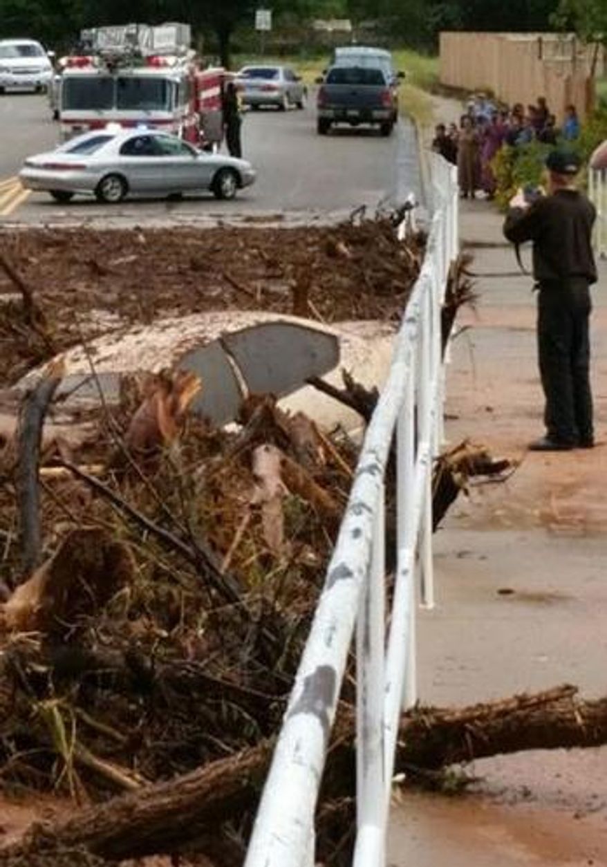A vehicle rests in debris after a flash flood Monday, Sept. 14, 2015, in Hildale, Utah. Authorities say multiple people are dead and others missing after a flash flood ripped through the town on the Utah-Arizona border Monday night. (Mark Lamont via AP)