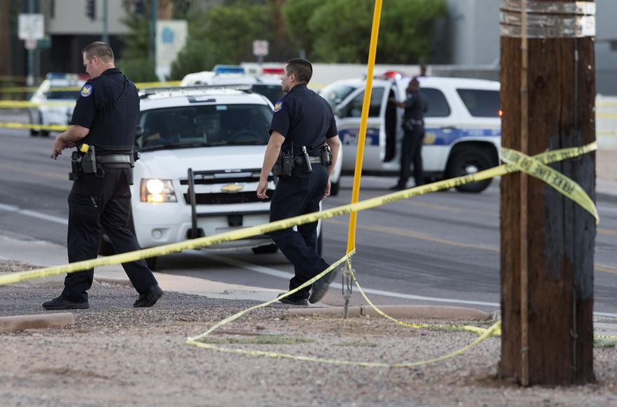 Phoenix police officers arrive at the scene where a Phoenix police officer was shot early Wednesday, Sept. 16, 2015 in Phoenix, Ariz. Sgt. Jonathan Howard says the officer reported being shot while making a traffic stop of a Ford Thunderbird sedan carrying two people. Howard says officers found the wounded officer on the ground and that his vest likely saved his life. The officer is hospitalized in serious condition. Police are still searching for the suspects. (Emmanuel Lozano/The Arizona Republic via AP) MARICOPA COUNTY OUT; MAGS OUT; NO SALES; MANDATORY CREDIT