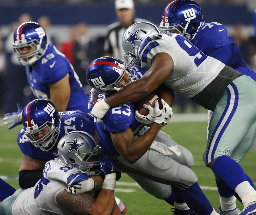 New York Giants running back Rashad Jennings (23) is tackled by Dallas Cowboys defensive tackle Nick Hayden (96) and Jeremy Mincey (92) during the second half of an NFL football game, Sunday, Sept. 13, 2015, in Arlington, Texas. Dallas won 27-26. (Jose Yau/Waco Tribune-Herald via AP)