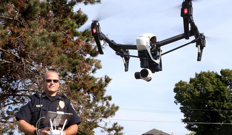 ADVANCE FOR MONDAY SEPT. 21 - In this Sept. 16, 2015 photo, West Salem police chief Charles Ashbeck flies his department’s new drone in West Salem, Wis. The West Salem Police Department is one of a handful of law enforcement agencies in Wisconsin using a drone. (Peter Thomson/La Crosse Tribune via AP) MANDATORY CREDIT