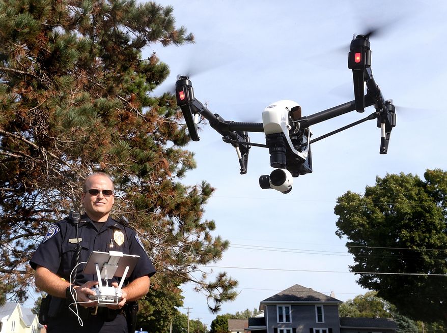 ADVANCE FOR MONDAY SEPT. 21 - In this Sept. 16, 2015 photo, West Salem police chief Charles Ashbeck flies his department’s new drone in West Salem, Wis. The West Salem Police Department is one of a handful of law enforcement agencies in Wisconsin using a drone. (Peter Thomson/La Crosse Tribune via AP) MANDATORY CREDIT
