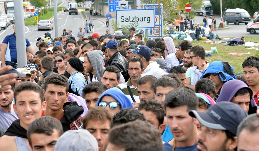Refugees wait on a bridge after police stopped them at the border between Austria and Germany in Salzburg, Austria, Thursday, Sept. 17, 2015. (AP Photo/Kerstin Joensson)