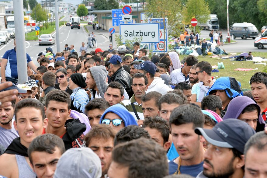 Refugees wait on a bridge after police stopped them at the border between Austria and Germany in Salzburg, Austria, Thursday, Sept. 17, 2015. (AP Photo/Kerstin Joensson)