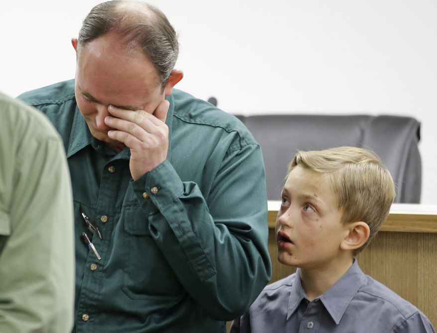 Sheldon Black, Jr., lowers his head as one of his two surviving sons looks on during a news conference Thursday, Sept. 17, 2015, in Colorado City, Ariz. Black expressed his gratitude for the outpouring of support after his wife and children were swept away in a flash food Monday. (AP Photo/Rick Bowmer)