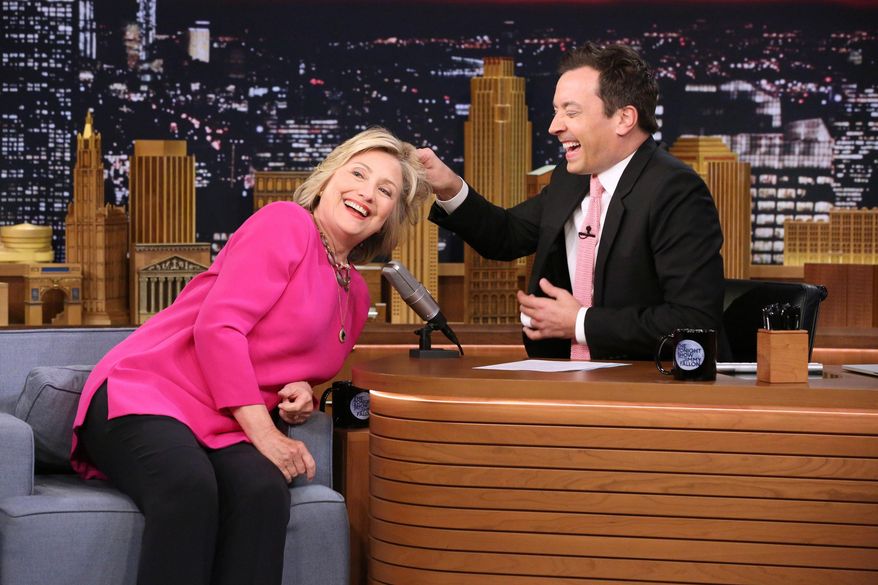 In this image released by NBC, Hillary Rodham Clinton, left, invites host Jimmy Fallon to pull her hair during a taping of "The Tonight Show Starring Jimmy Fallon," on Wednesday, Sept. 16, 2015, in New York. (Douglas Gorenstein/NBC via AP)