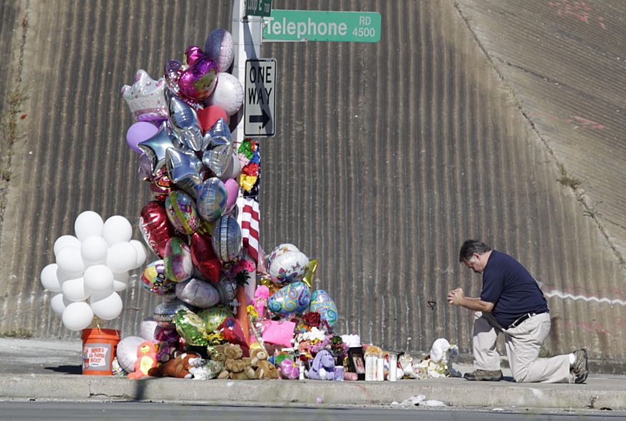 A man prays the site of an accident that involved a school Wednesday, Sept. 16, 2015, in Houston. The bus plunged off a highway overpass in Houston after being hit by a car Tuesday, injuring multiple students and killing two, police and school officials said. (James Nielsen/Houston Chronicle via AP) MANDATORY CREDIT