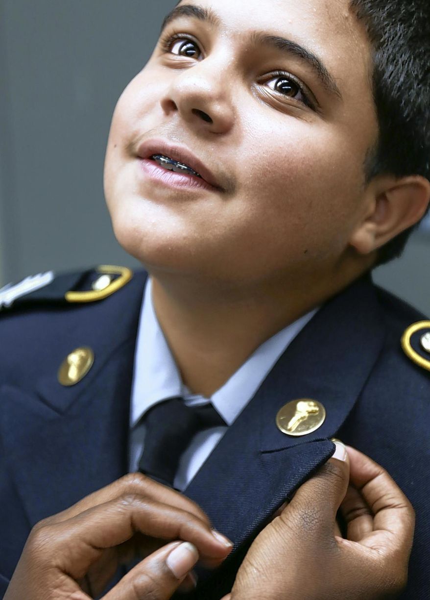 In this photo taken on Thursday, Sept. 10, 2015, J.H. Rose ROTC Staff Sergeant Laith Hamed get assistance with his pins after receiving his new uniform in the ROTC Building at J.H. Rose High School in Greenville, N.C. (Aileen Devlin /The Daily Reflector via AP) MANDATORY CREDIT