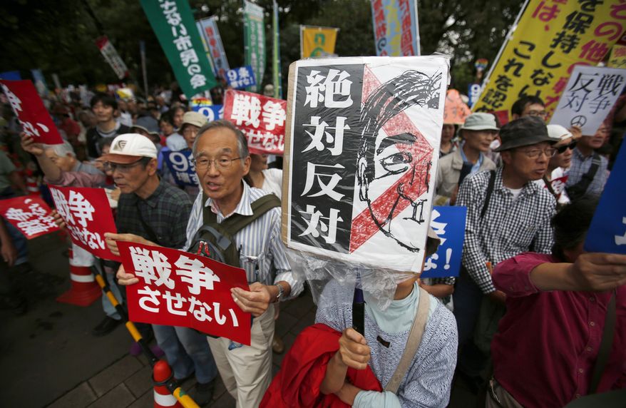 Protesters holding "No war" placards stage a rally against Japanese government in front of the parliament building in Tokyo, Friday, Sept. 18, 2015. Japan's parliament is moving toward final approval of legislation that would loosen post-World War II constraints placed on its military, an issue that has sparked sizable street protests and raised fundamental questions about whether the nation needs to shift away from its pacifist ways to face growing security challenges. (AP Photo/Koji Ueda)