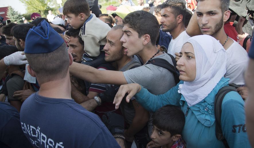 Migrants board a bus in Baranjsko Petrovo Selo, at the Hungarian border, northeast Croatia, Friday, Sept. 18, 2015. Croatia has sent buses full of migrants to Hungary just hours after the country's prime minister said it could not cope with the influx. But Hungarian police met the convoy of 19 buses in the border area and refused to let them cross in. (AP Photo/Darko Bandic)