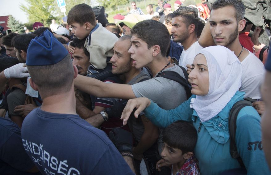 Migrants board a bus in Baranjsko Petrovo Selo, at the Hungarian border, northeast Croatia, Friday, Sept. 18, 2015. Croatia has sent buses full of migrants to Hungary just hours after the country's prime minister said it could not cope with the influx. But Hungarian police met the convoy of 19 buses in the border area and refused to let them cross in. (AP Photo/Darko Bandic)