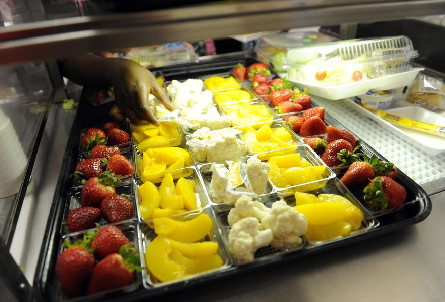 FILE - In this April 29, 2014, file photo, fruit and vegetables are served during lunch at the Patrick Henry Elementary School in Alexandria, Va. Congress will have to decide soon whether it wants another food fight with first lady Michelle Obama and the administration over what’s served in the school lunch line. School food rules pitted Republicans seeking full exemptions for some schools against Obama in 2014, with the first lady declaring she'd fight "to the bitter end" to make sure kids have good nutrition. (AP Photo/Susan Walsh, File)
