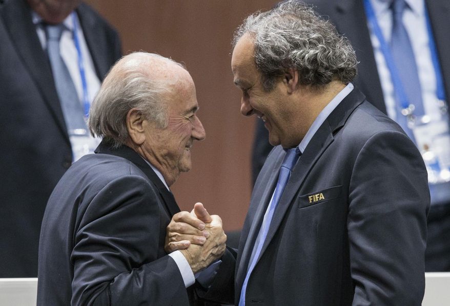 FILE - In this Friday, May 29, 2015 file photo, FIFA president Sepp Blatter after his election as President, left, is greeted by UEFA President Michel Platini, right, at the Hallenstadion in Zurich, Switzerland. At the start of his seventh decade and his third term as UEFA president, Michel Platini still seems to prefer to do much of his talking on the pitch despite being the most powerful figure in European football and the favorite to be installed as Sepp Blatter's FIFA successor in February 2016. (Patrick B. Kraemer/Keystone via AP, File)